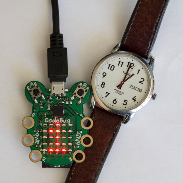CodeBug in front of a clock